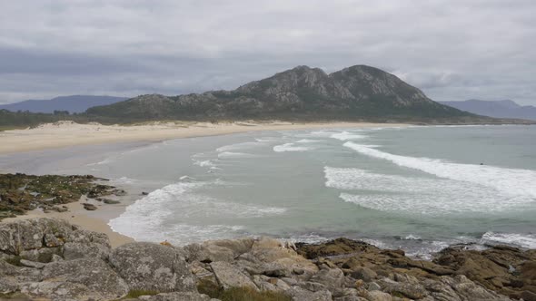 Punta Canton amazing landscape view with mountain, beach and surfers on the atlantic ocean in Spain