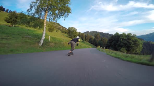 A skateboarder downhill skateboarding racing on a mountain road.