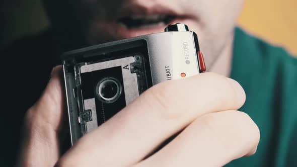 A Young Man Is Recording His Speech on a Portable Retro Cassette Recorder