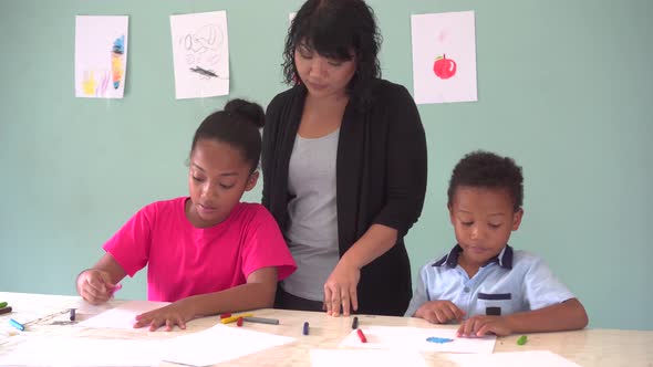 Young Teacher Giving African American Kids an Art Lesson and Teaching How to Draw