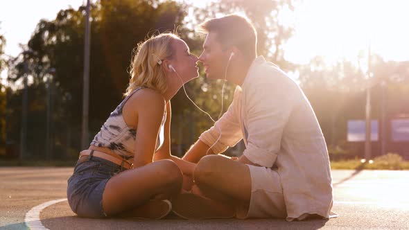 Happy Couple with Smartphone and Earphones Kissing