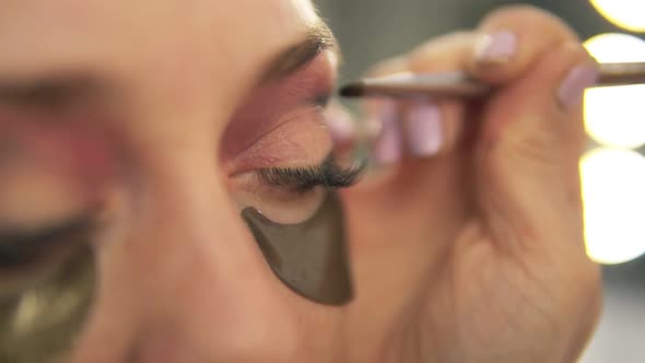 Makeup Artist Applying Eye Shadow to Model's Eye