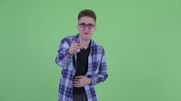 Happy Young Hipster Man Laughing and Pointing at Camera