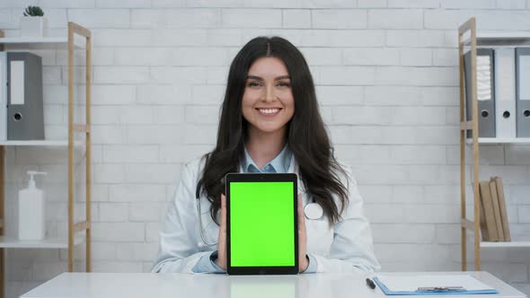 Female Doctor Showing Digital Tablet With Green Screen In Clinic