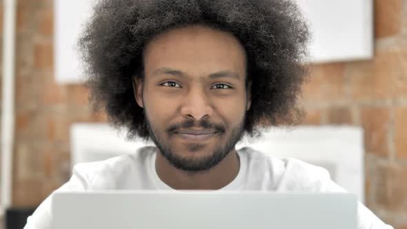 Thumbs Down By African Man Working on Laptop