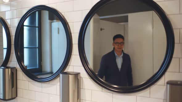 Asian Businessman Visiting Public Restroom in Restaurant or Business Center