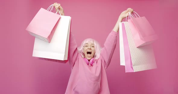 Happy Girl Enjoys After Shopping with Colorful Bags in Pink Colour Concept