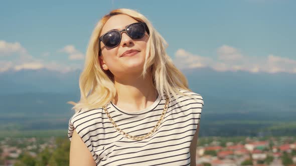 Pretty Caucasian Girl with Sunglasses on the Beautiful Town Background Medium Closeup