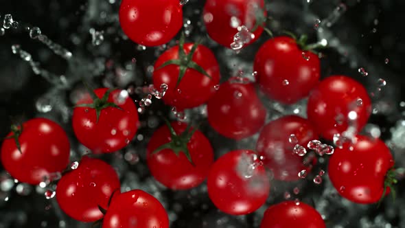 Super Slow Motion Shot of Flying Cherry Tomatoes with Water Towards the Camera at 1000Fps