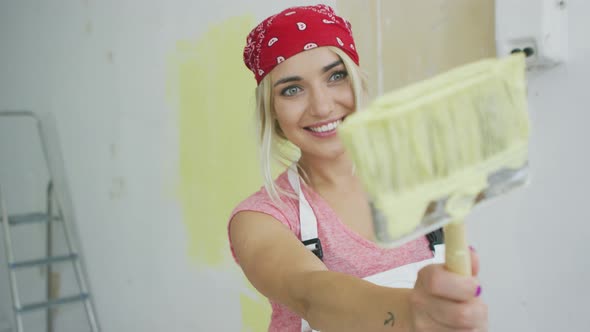 Happy Female Painter Pointing with Brush