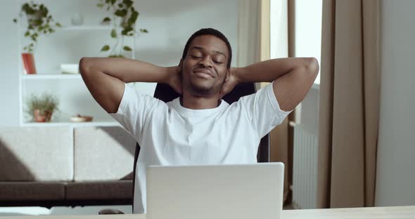 Portrait of Smiling Contented African American Black Man in White Tshirt Sits at Table with His