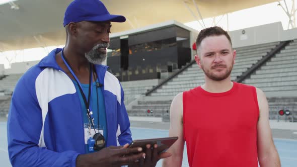 African american male coach and caucasian athlete talking during training session