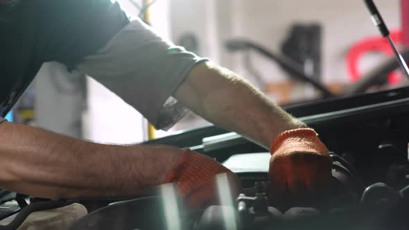 Auto mechanic repairs automobile engine. auto repair station. close-up.