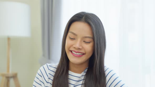 Portrait of Asian beautiful woman sit on sofa in living room at home.