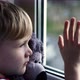 Little Boy Stares Sadly Out of a Window with a Teddy Bear in Her Arms - VideoHive Item for Sale