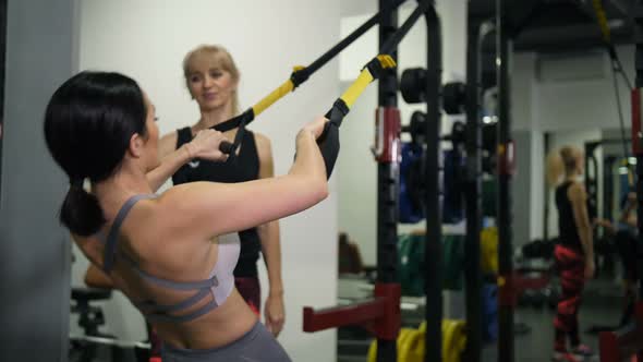 Athletic Girl Doing Pullups Under the Guidance of a Female Trainer  Slow Mo