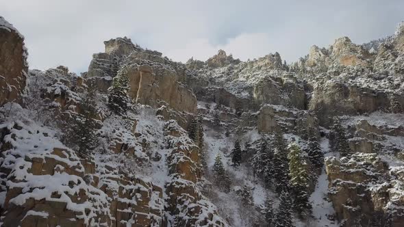 Flying up and over snow cover cliffs during winter