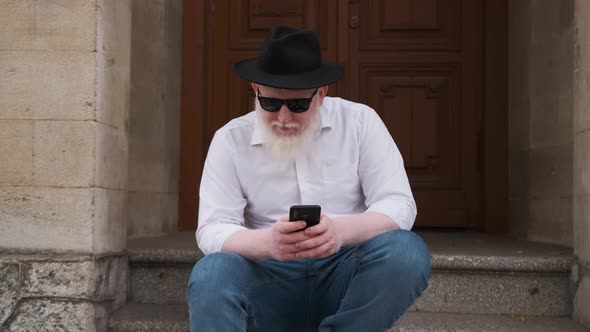 Man Suffering From Albinism Sits Outside and Surf the Internet