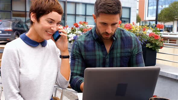 Business colleagues working while having coffee in cafeteria