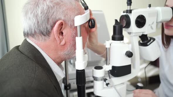 Ophthalmologist Examination of Elderly Man with Slit Lamp