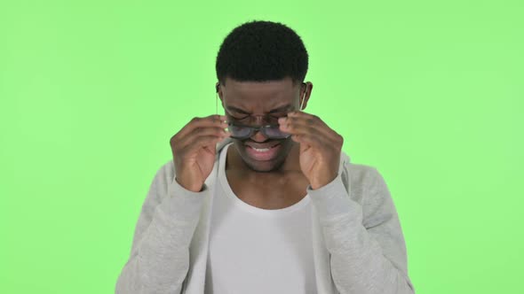 African Man Having Headache on Green Background