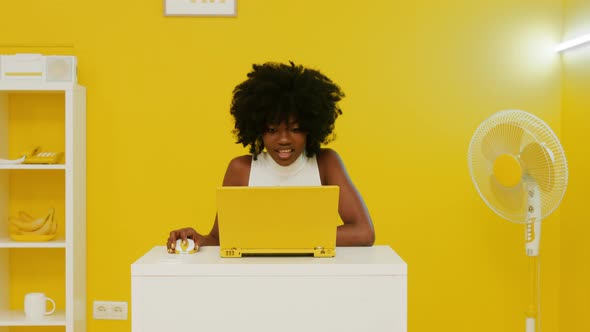 Cheerful African Woman Is Working at Laptop