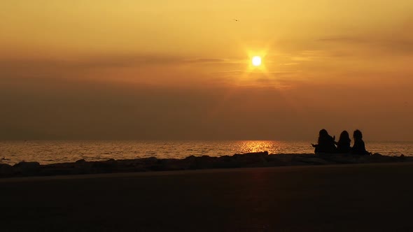 People Sitting On Golden Sunset