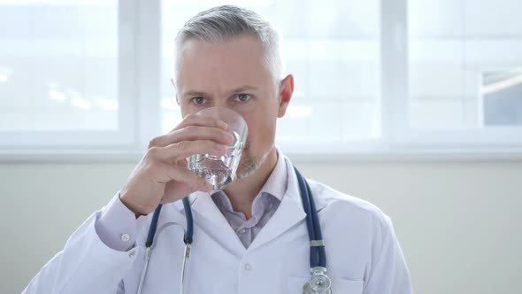 Doctor Drinking Water in Clinic