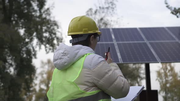 Worker inspects the solar panels and reports the information to the management