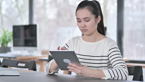 Digital Tablet Use By Beautiful Young Asian Woman in Office