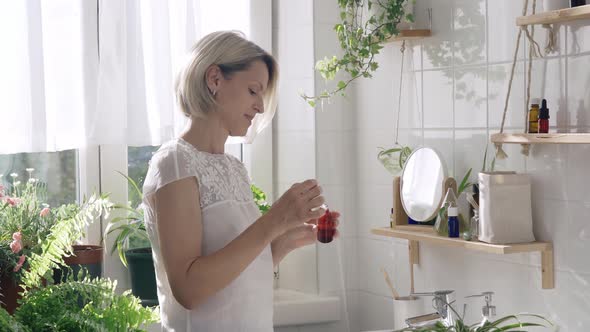 Woman Using Cosmetics in Eco Friendly White Bathroom