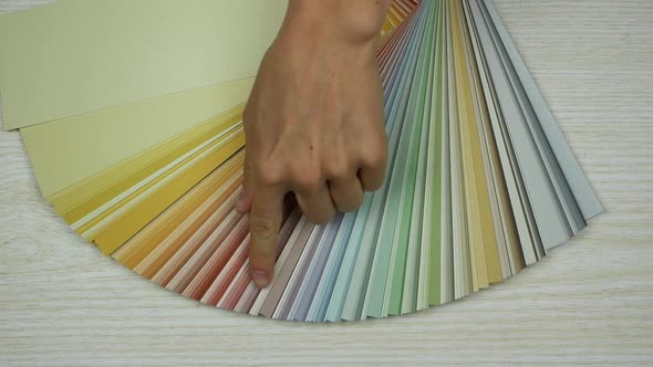Finger pointing on one color in a palette of colours