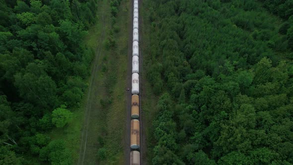 The Train Transports Tanks of Crude Oil Among Virgin Ecological Green Forests