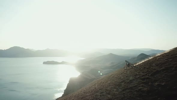 Drone View of Man on Motorbike Extremely Rides Across the Hills with Black Sea on Background