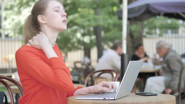 Young Woman with Neck Pain Using Laptop Outdoor
