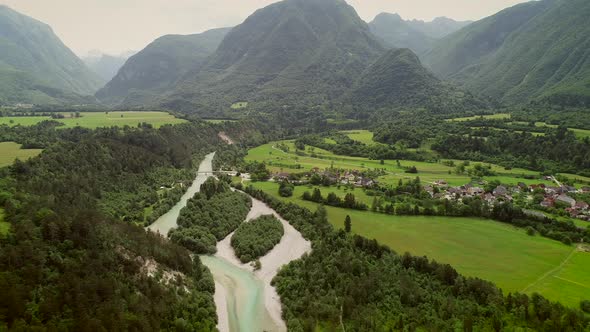 Aerial view of a small village with typical houses next to Soca river, Slovenia.