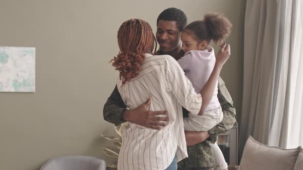 Military Man Reuniting with Family at Home alt