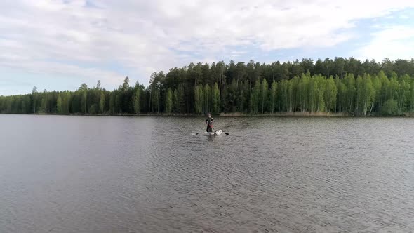 Aerial view of lake surrounded by a forest with fishermens