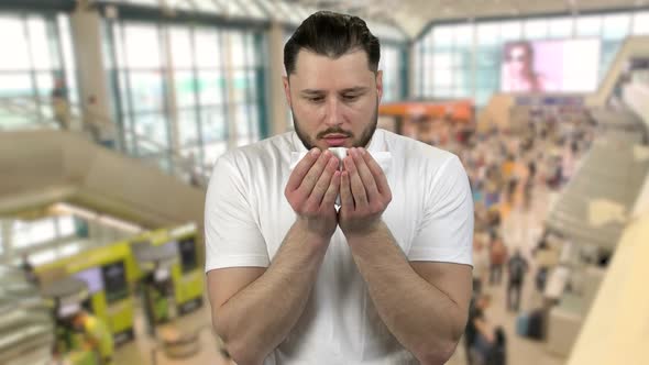 Portrait of Man in a City Mall or Airport Sneezing with Blood