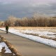Senior male cyclist is riding a touring bike on a paved trail in winter scenery  - VideoHive Item for Sale
