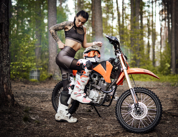 it with semi naked torso posing next to her bikein the woods