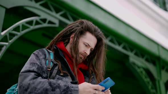 Male Tourist on Station in Winter Day Hipster is Using App in Smartphone Chatting Message