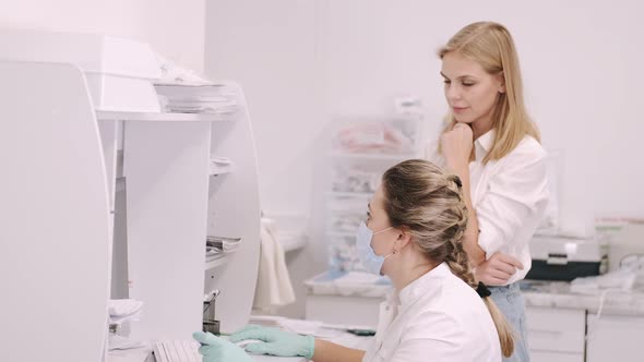 Patient and Doctor Discusing Blood Test Looking at Computer Database