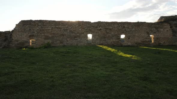 Sun shining behind a stone wall