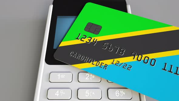 Plastic Bank Card with Flag of Tanzania and Payment Terminal