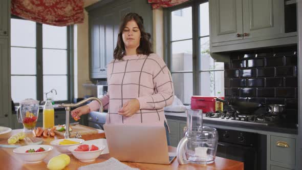 Caucasian vlogger woman doing a cooking video at home