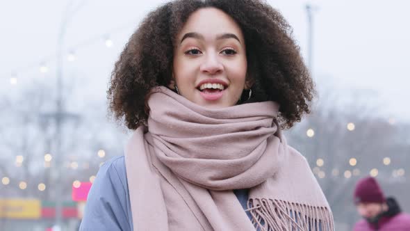 Portrait of Young Mixed Race Girl with Curly Hair in Outerwear with Pink Scarf Stands on Street in