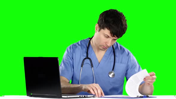 Doctor Takes Notes While Touching Laptop. Green Screen