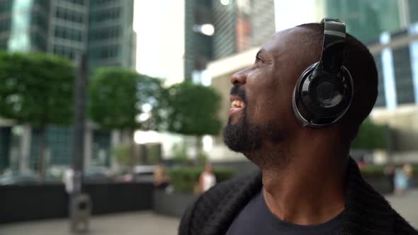 Slow Motion Close Up Face of a Happy African American with Headphones Listening To Music on the