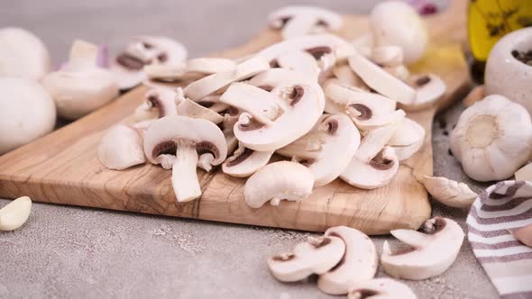 Sliced and Chopped Champignon Mushrooms on a Wooden Cutting Board